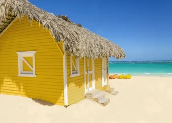 Wooden yellow hut on the beach covered with thatch and kayaks. most valuable commodity