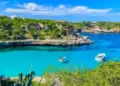 Summer vacation scene with sailboats on turquoise clean water on Mallorca Island near Cala Llombards beach.