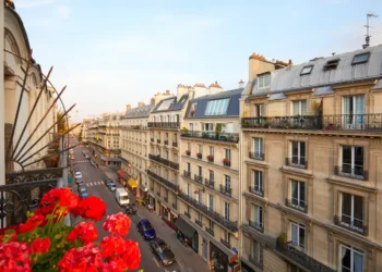 Paris, ancient buildings facades and street in a warm summer sunset in France