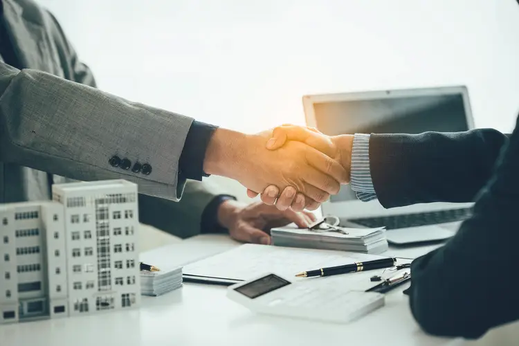 Sales representative shakes hands with a client to come to an agreement on the real estate sales. Starting a Business in Brazil