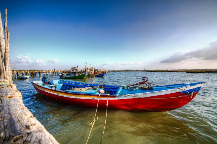 Colorful Fishing Boat at Porto Palafitico, Carrasqueira, Portugal. cost of living in comporta