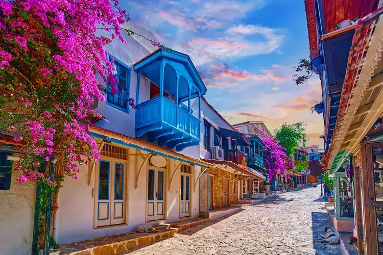 Old colored street view. White houses with wooden blue balconies and pink flowers in Kas city, Turkey. kas