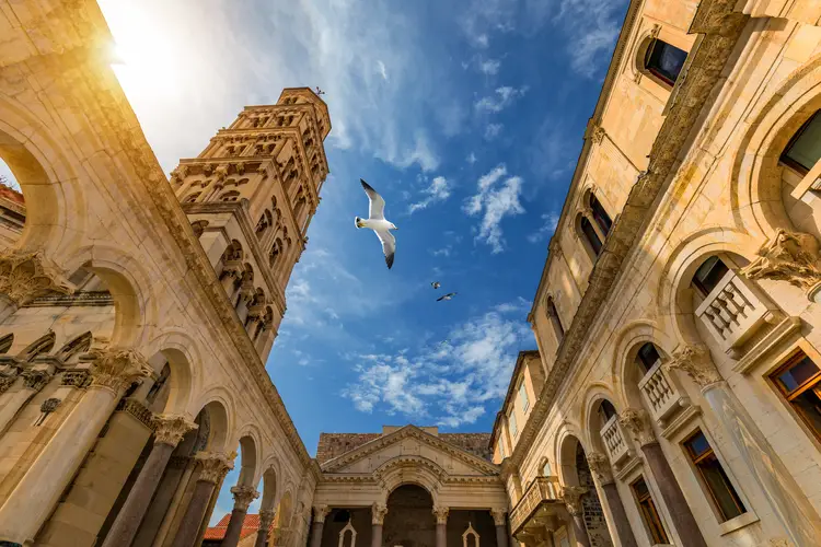 Diocletian's Palace's peristyle in front of Cathedral of Saint Domnius' bell tower in Split, Croatia. Diocletian palace UNESCO world heritage site in Split. cost of living in croatia