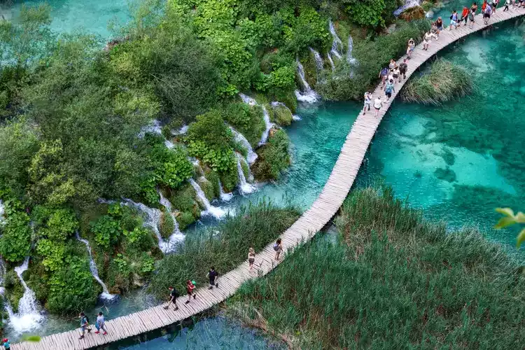 Aerial view at wooden hiking path through water besides waterfalls in Plitvice Lakes National Park, Croatia. infrastructure in croatia