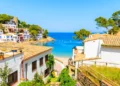 White houses with orange tile roofs and steps to beach in Sa Tuna coastal fishing village, Costa Brava, Spain