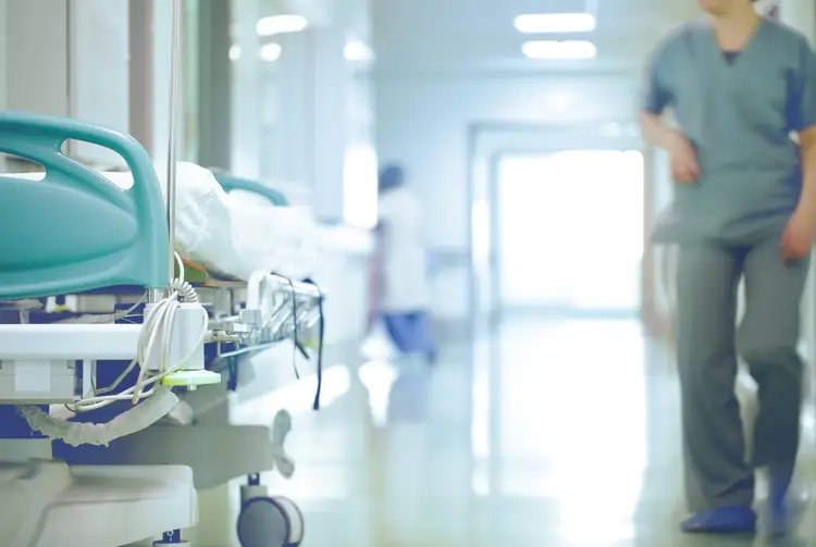 A Doctor Walking past a bed