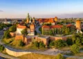 Poland. Krakow skyline with Wawel Hill, Cathedral, Royal Wawel Castle, defensive walls,Vistula riverbank, park, promenade, walking people.