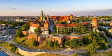 Poland. Krakow skyline with Wawel Hill, Cathedral, Royal Wawel Castle, defensive walls,Vistula riverbank, park, promenade, walking people.