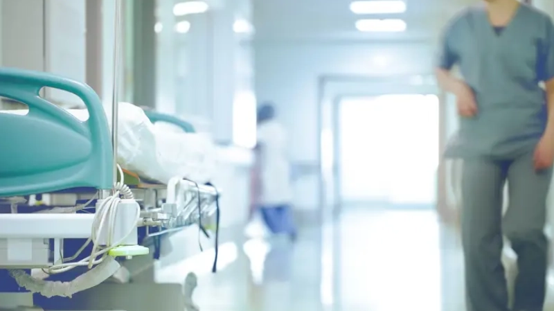 A Doctor Walking past a bed