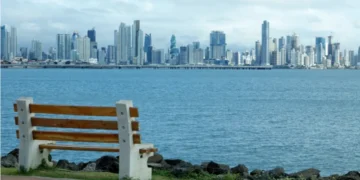 Panama City skyline viewed from waterfront park with bench in foreground