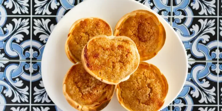 Traditional Portuguese pastry called Queijada de Sintra on portuguese tiles background