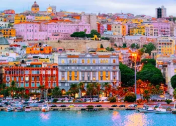 Old Sardinian Port with ships at Mediterranean Sea and city of Cagliari, South Sardinia Island in Italy in summer. Cityscape with marina and Yachts and boats in town