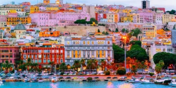 Old Sardinian Port with ships at Mediterranean Sea and city of Cagliari, South Sardinia Island in Italy in summer. Cityscape with marina and Yachts and boats in town