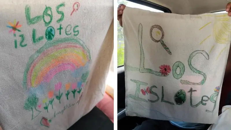 two fabric bags decorated with colorful, childlike drawings and the handwritten phrase “Los Islotes,”