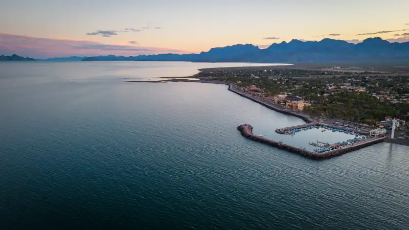drone fly above Loreto Baja California Sur Mexico old colonial town with sea gulf ocean and mountains desert landscape at sunset