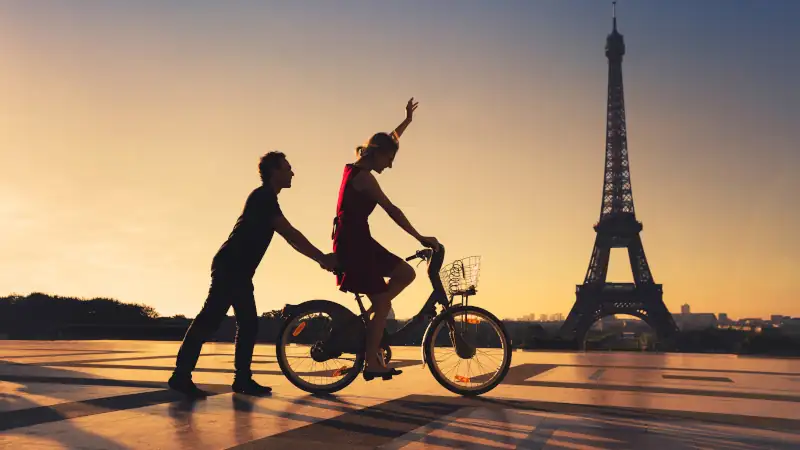 happy couple having fun in Paris riding bicycle near Eiffel tower, silhouettes