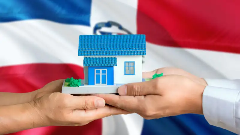 Dominican Republic real estate concept. Man and woman holding miniature house in hands.