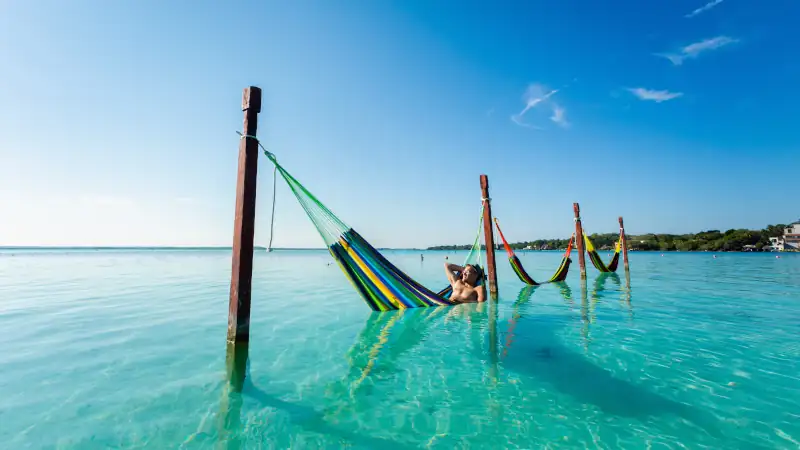 Man on hammock in Bacalar lagoon Mexico