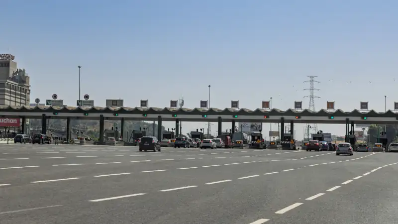 A wide shot of a multi-lane toll plaza on a highway in Portugal.