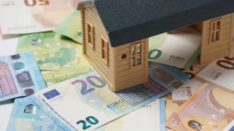 Concept of home ownership. New house and Euro money as a background. Invest in real estate