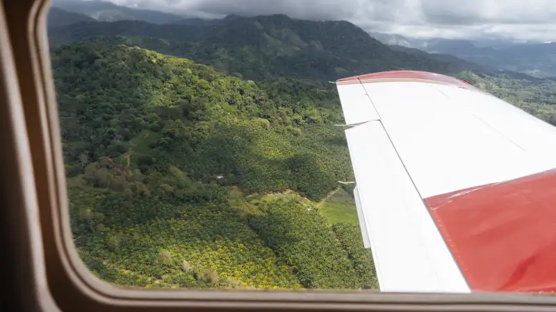 A small plane flying over the mountains of Costa Rica, view from inside the aircraft