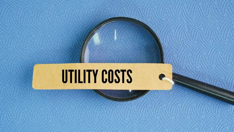 Magnifying glass and paper tag with the word utility costs.