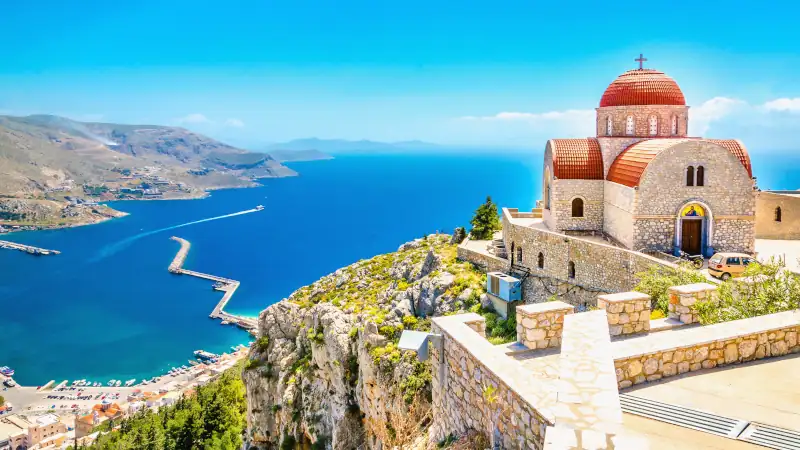Remote church with red roofing on cliff, Greece