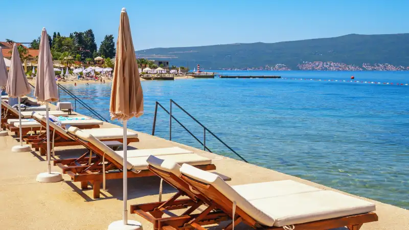 Beach vacations, chaise lounges and beach umbrellas. Montenegro, Bay of Kotor, Tivat