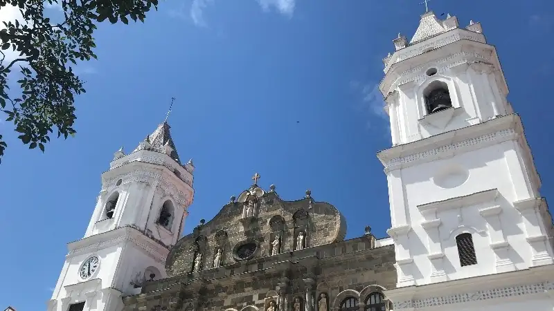 Panama City cathedral with ornate stone facade and white bell towers.