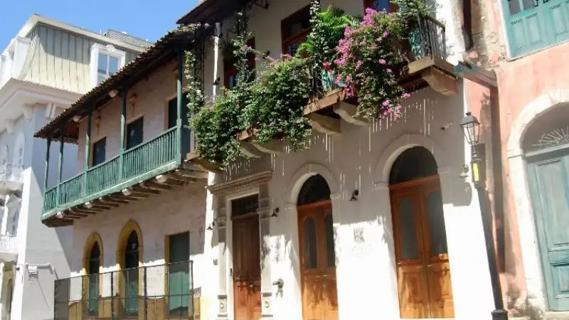 Colorful colonial-style houses with wooden balconies and flowering plants.