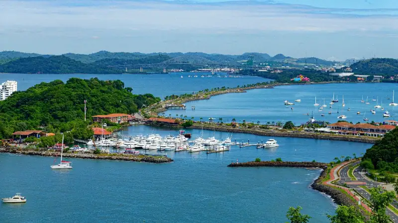 A scenic view of Panama City’s marina, with boats, lush greenery, and the bay stretching toward the distant hills.