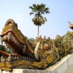 An elaborate dragon on temple stairs in Laos