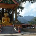 A gold Buddhist statue under a roof in VangVieng Laos