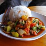 A plate of laosian stew with white rice