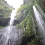 A tall waterfall cave in indonesia with vines growing