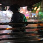 Night falls as a motorcycle rickshaw drives through the rain in Phnom Penh.