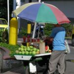 A Colombian fruit vendor slices watermelon.