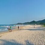 Families walk along Tayrona beach in Colombia.