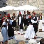 Couples in traditional Croatian dress folkdance.