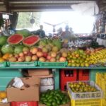 Fresh fruit in Belize market including bananas, papaya, mangos, and cut watermelons to entice buyers