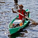 A man in a small green boat in Belize