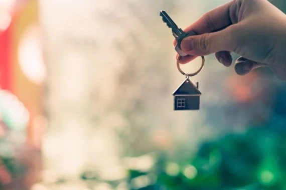 A hand holding a key with house keyring. subsidized health care